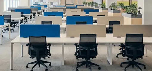 Modern open-plan office space featuring clean workstations, ergonomic chairs, and sanitized carpets provided by professional office cleaning services in Eugene, OR.