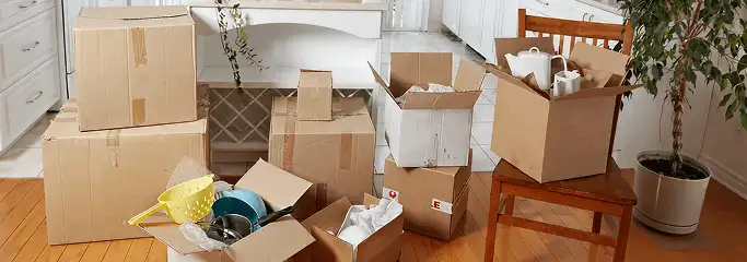 Packed moving boxes and household items in a kitchen before move-out or move-in cleaning, Eugene, OR.